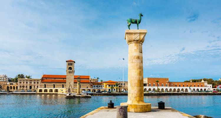 Seafront with a column topped by a bronze deer statue.