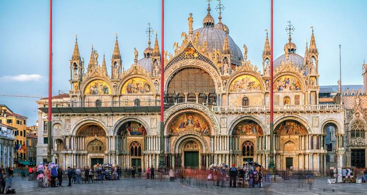 Cathédrale historique avec des mosaïques complexes et des arches, des gens rassemblés devant.