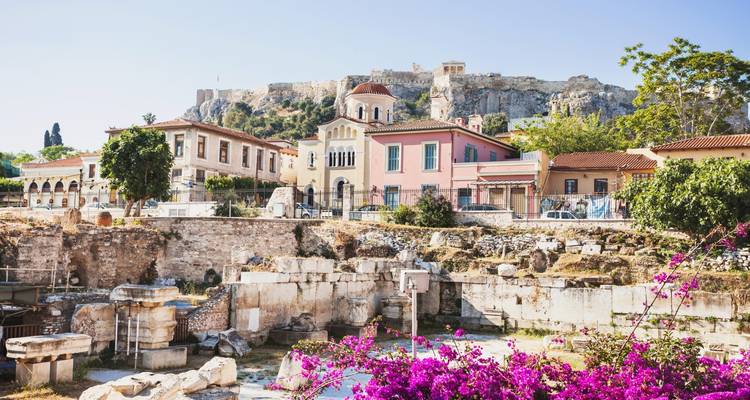 Colorful buildings with a view of ancient ruins and a distant hilltop fortress.