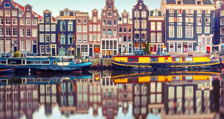 Kanal in Amsterdam mit traditionellen schmalen niederländischen Häusern und Hausbooten.