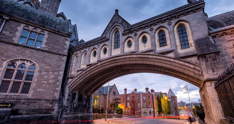Pont d'architecture gothique entre deux bâtiments au crépuscule dans une ville historique.