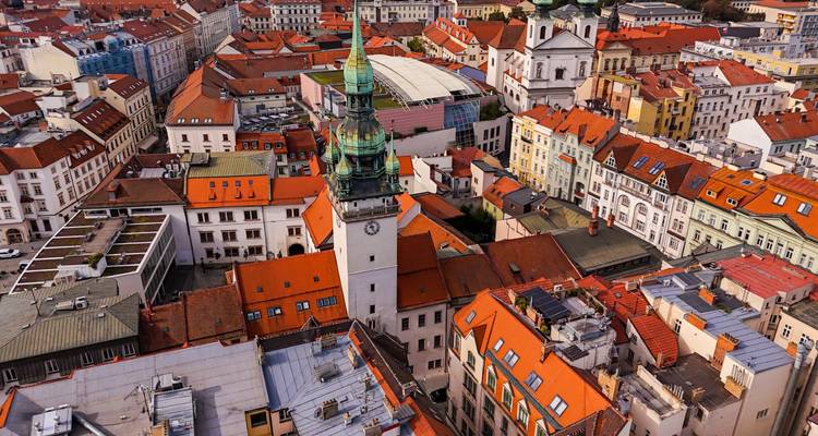 Drohnenbild von Brnos historischem Zentrum mit dem markanten Rathausturm, der die labyrinthartigen Straßen und Ziegeldächer überragt.