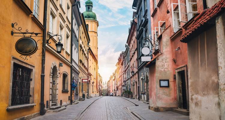 Rue étroite avec des bâtiments historiques à Varsovie, Pologne sous un ciel dégagé.