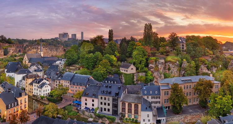Schilderachtig dorp met weelderig groen en historische ruïnes tijdens zonsondergang.