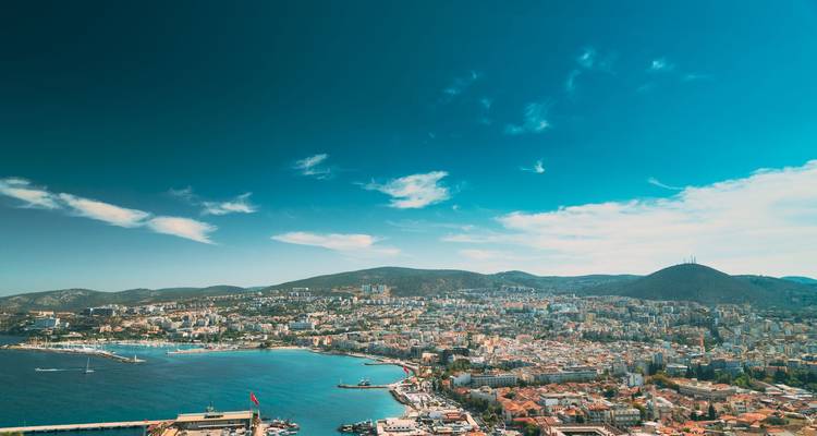 Vista panorámica de una ciudad costera con cielos azules.