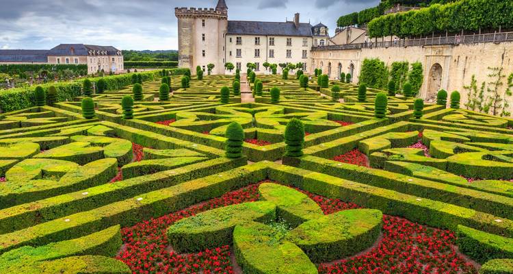 Jardins ornés avec une structure semblable à un château en arrière-plan.