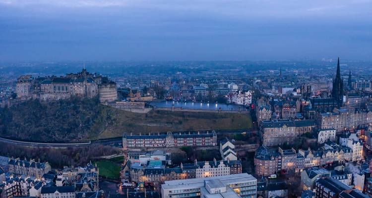 Une vue panoramique d'une ville dominée par un grand château au sommet d'une colline.