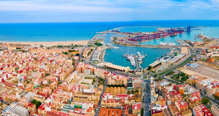 Aerial view of a coastal city with a marina and colorful buildings.