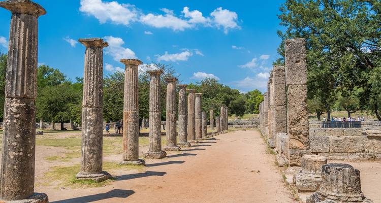 Ancient ruins and columns in Olympia, Greece on a sunny day.