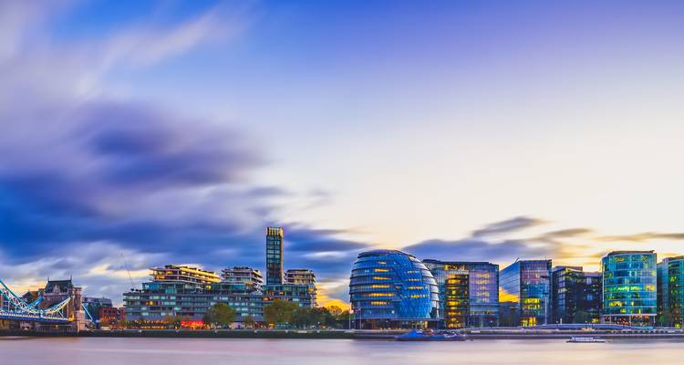 London's riverside with modern architecture and dramatic evening sky.