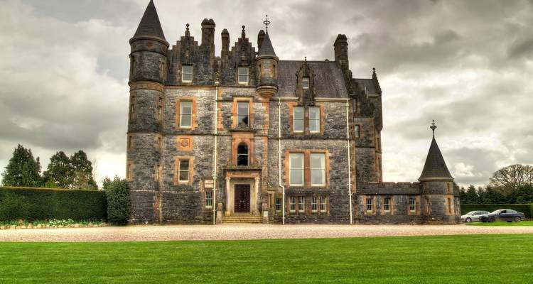 A dramatic looking castle with turrets under a cloudy sky.