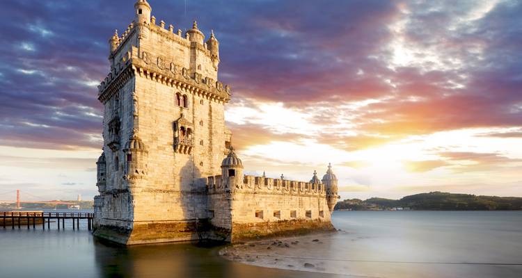 Belém-Turm in Lissabon bei Sonnenuntergang mit ruhigem Meer.