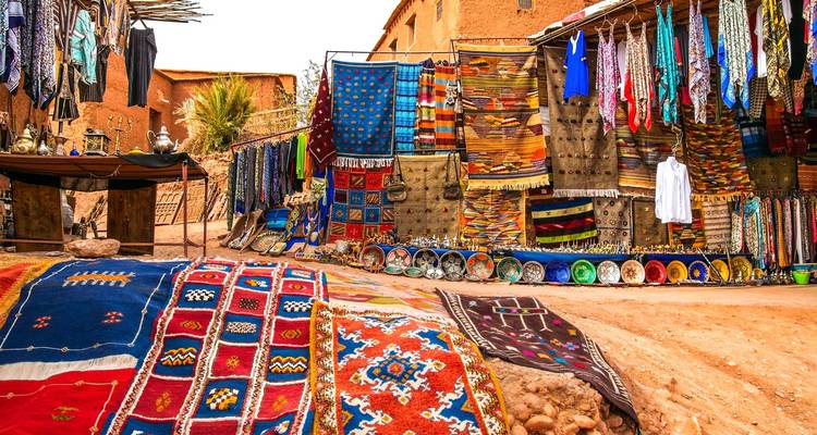 Marché coloré avec textiles et poteries exposés dans une ville du désert.