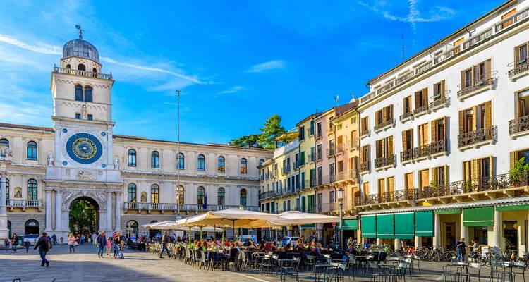 Plaza vibrante con cafeterías al aire libre y arquitectura histórica en Padua.