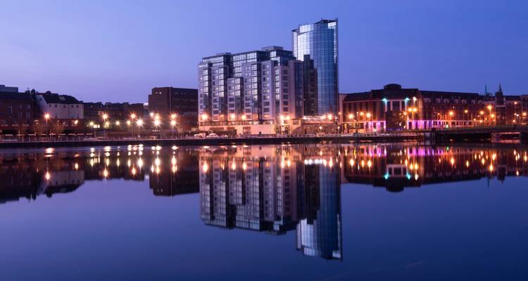 Bâtiments modernes au bord de l'eau au crépuscule.