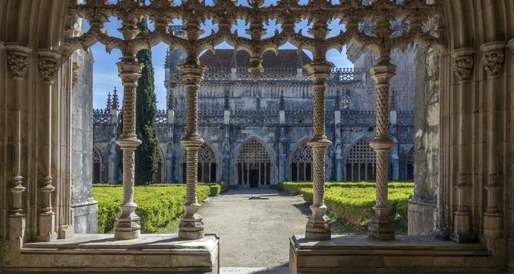 Cloisters of a medieval monastery with arches and garden.