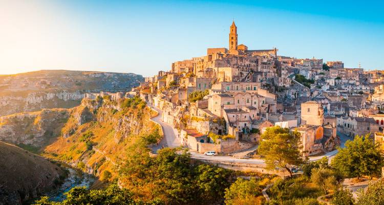 La ville de Matera avec des habitations troglodytiques et une église historique au coucher du soleil.