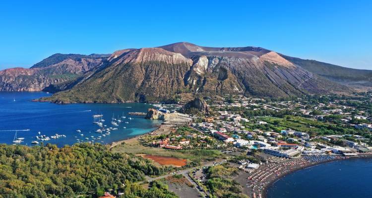 Volcanic island landscape with clear waters and lush greenery.