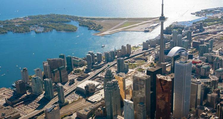 Panorama aérien de Toronto mettant en vedette la Tour CN, le Centre Rogers et les îles de Toronto entourées par le lac Ontario.
