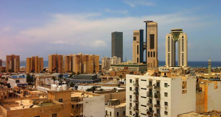 Skyline view with modern buildings and the sea in the background.