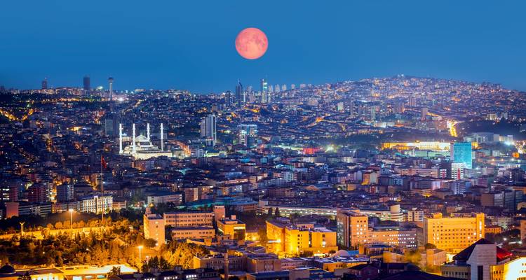 Ankara cityscape with a rising full moon.