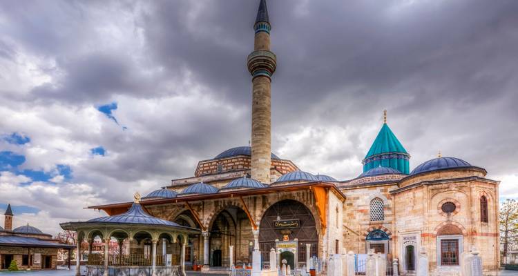 Mosque with a green dome and cloudy sky