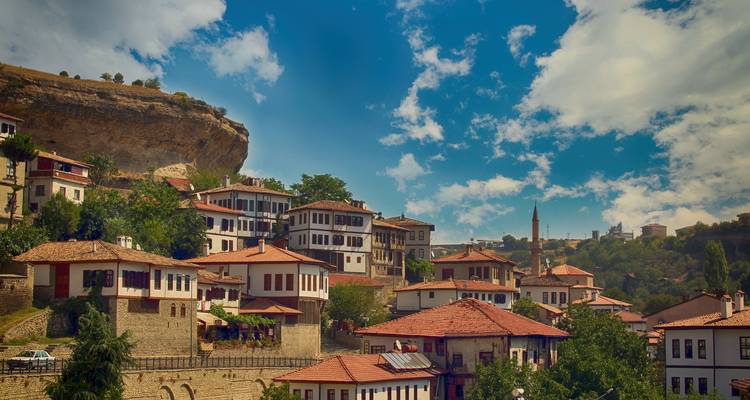 Quaint village with traditional houses and a backdrop of hills.