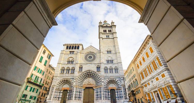 Catedral gótica vista a través de un arco y rodeada de edificios.