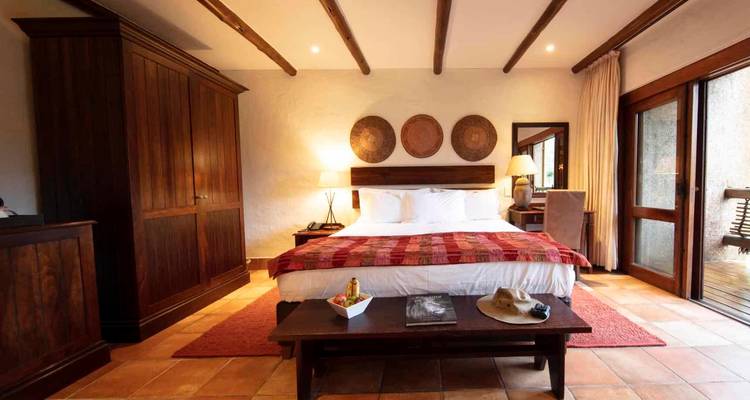 Luxurious hotel room with a king-sized bed and wooden furnishings.