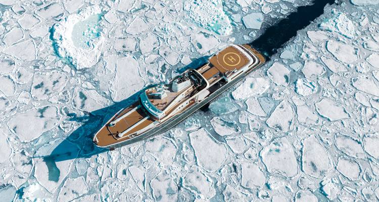 Vue aérienne d'un navire fendant la glace avec un héliport sur le pont.