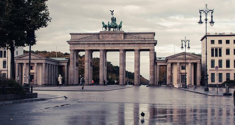La porte de Brandebourg se dresse fièrement après la pluie, se reflétant dans les flaques d'eau sur la paisible Pariser Platz.