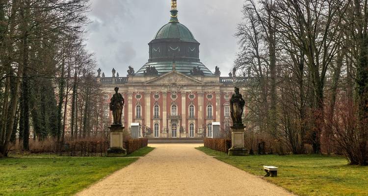 Le somptueux Neues Palais de Potsdam se dresse au bout d'un chemin de gravier bordé de statues par un matin brumeux.