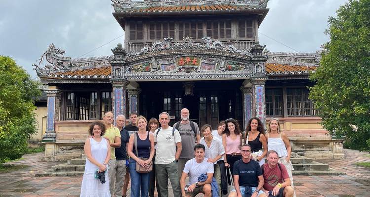 Groupe de personnes posant devant un bâtiment historique orné.