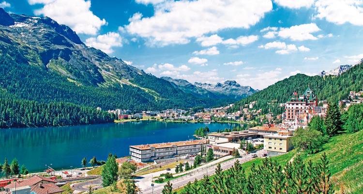 Seestadt mit Bergen im Hintergrund.
