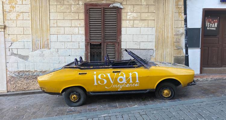 Yellow car parked on a street with vintage details.