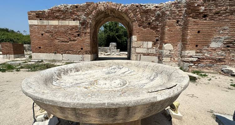 Old stone archway with an ancient basin in front.