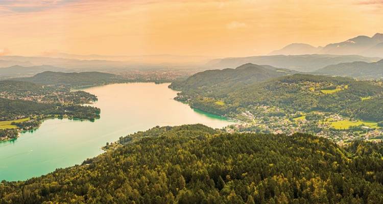 Luchtfoto van een meer omringd door bossen en bergen.