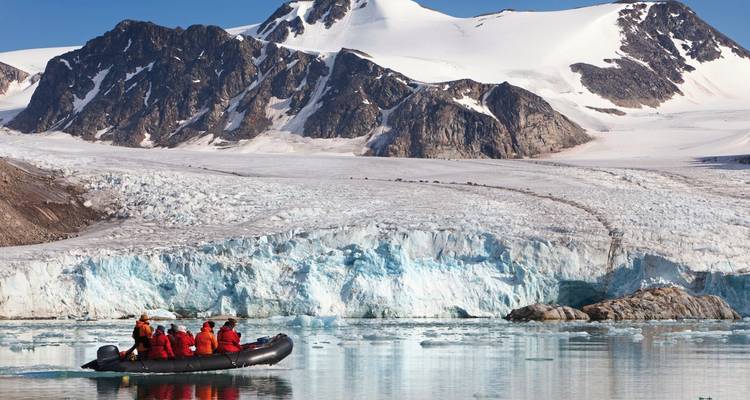 Groupe de personnes dans un bateau près d'un glacier dans un environnement arctique.