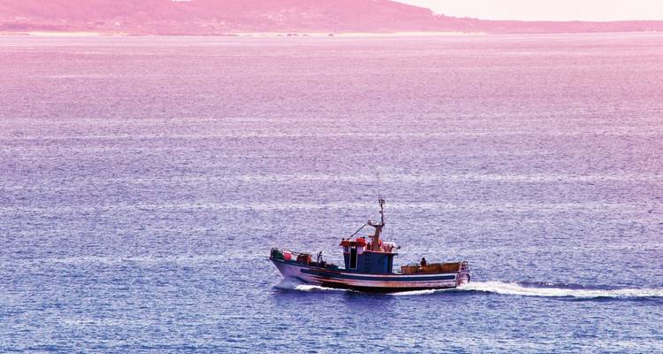Fishing boat sailing on a blue sea.