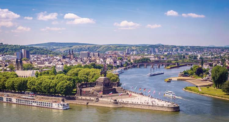 Vue aérienne d'une rivière avec une ville historique et un grand monument sur une péninsule.