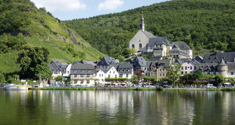 Charmante ville située le long d'une rivière avec des collines verdoyantes en toile de fond.