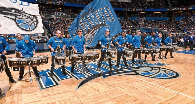 Spectacle de batterie de basketball avec des batteurs en uniformes bleus sur un terrain.