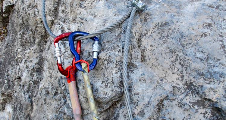 Close-up of climbing gear attached to a mountain rock surface.