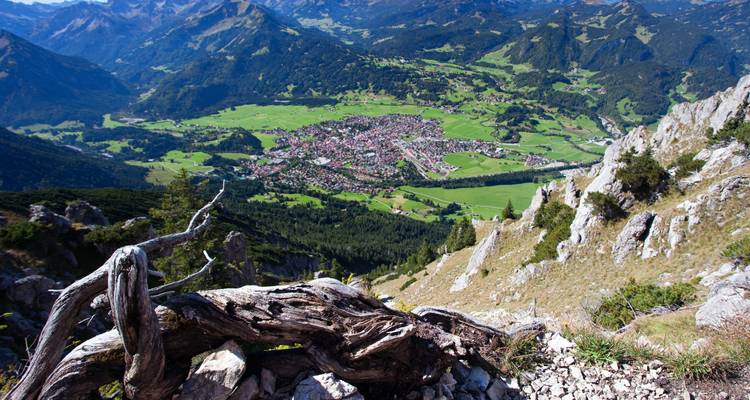 Mountainous landscape with a valley and a village in the distance.