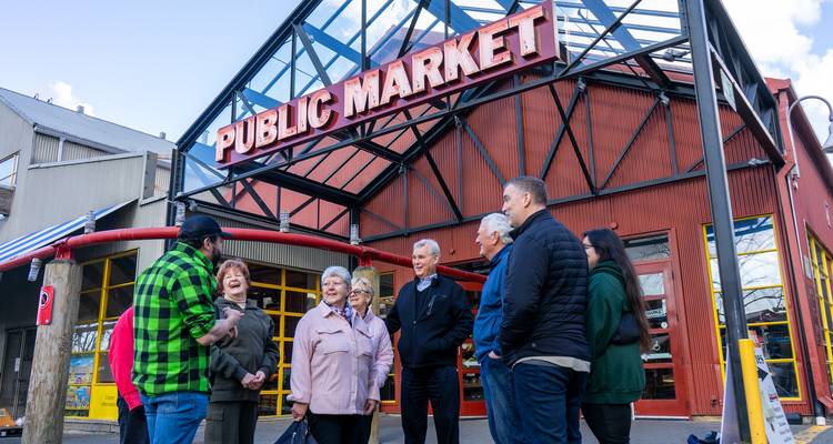 Groupe de personnes visitant l'entrée d'un marché public.