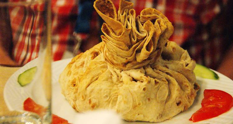 Nahaufnahme eines eingepackten Gerichts mit Beilagengemüse.