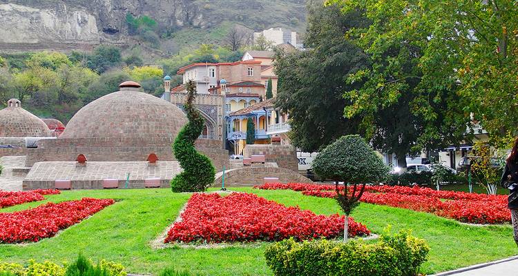 Garten mit bunten Blumen und historischer Architektur.