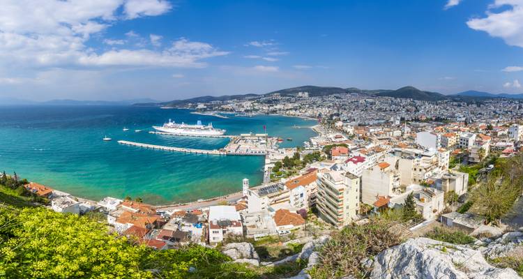 Luchtfoto van een kustplaats met een aangemeurd cruiseschip.