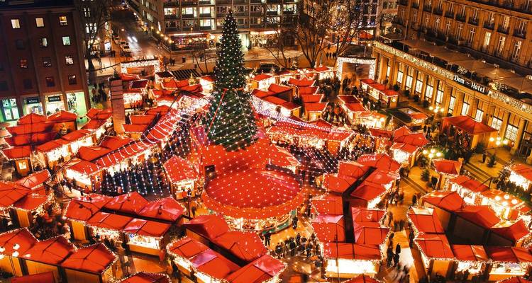 Vista aérea de un mercado navideño con luces brillantes y decoraciones.