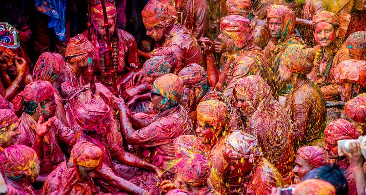 Grote groep mensen bedekt met kleurrijke poeders op een festival.